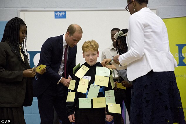 Prince William sticks a post-it note on Daniel, aged 11 from Derbyshire, who is an anti-bullying ambassador