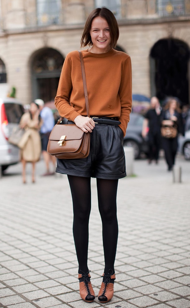 Девушка в коричневом свитере, коричневой сумкой на плече и в шортах