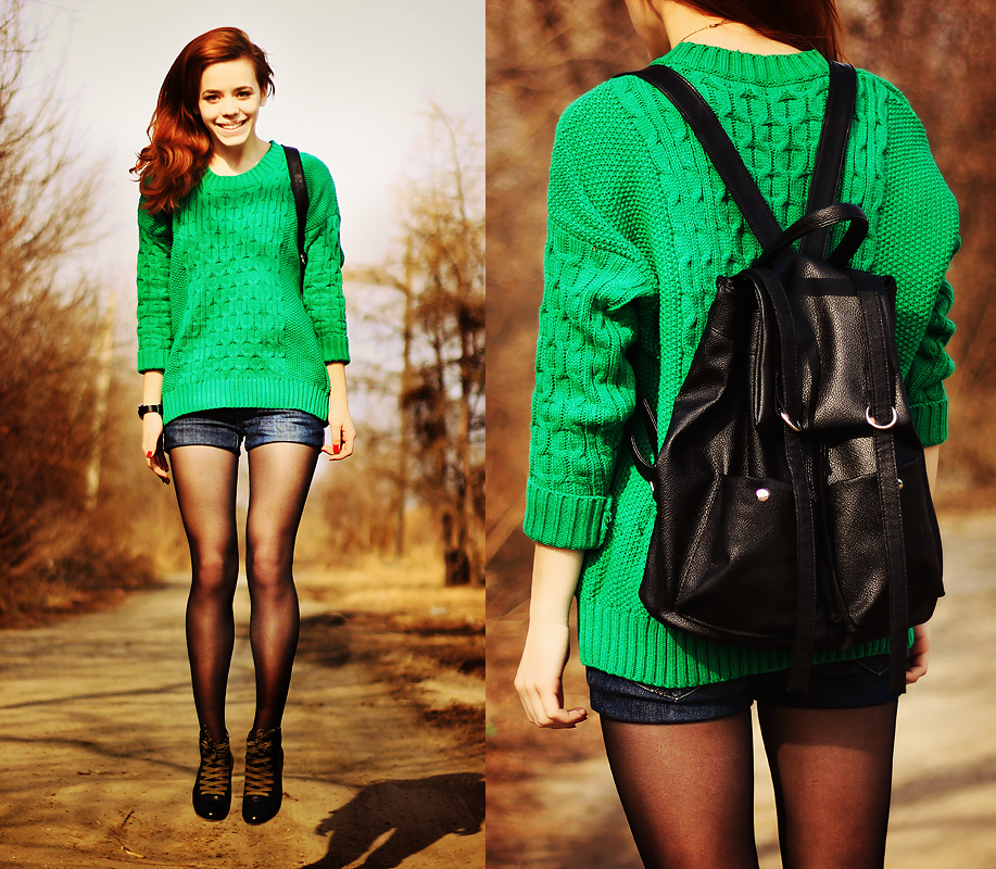 Рыжая девушка в коротких шортах и зеленом свитере