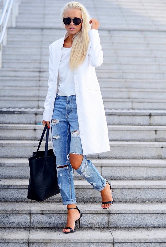Девушка в белом пальто, рваных джинсах и черных босоножках