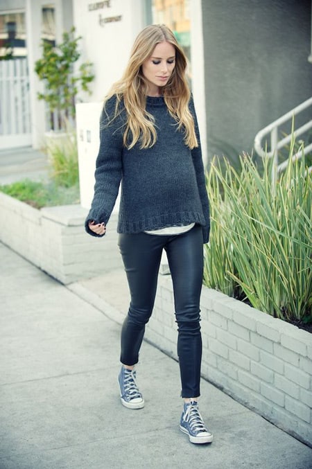 Беременная девушка в черных лосинах, вязаный свитер, кеды