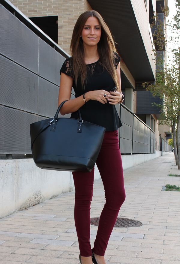 Девушка в черной блузке и винных джинсах