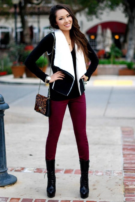 Девушка в черной куртке и бордовых джинсах