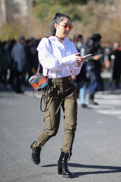 Девушка в брюках милитари с накладными карманами, белая блузка, черные ботинкм