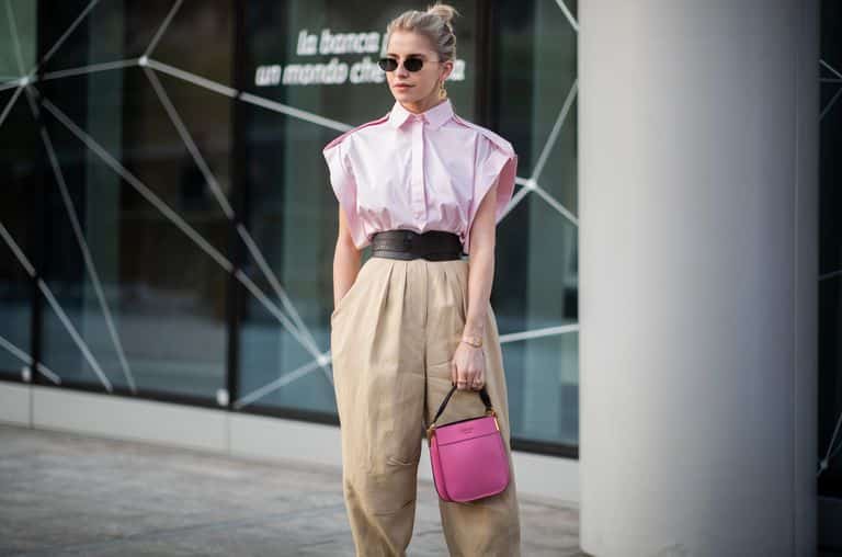 Девушка в бежевых широких брюках и розовой блузе без рукавов